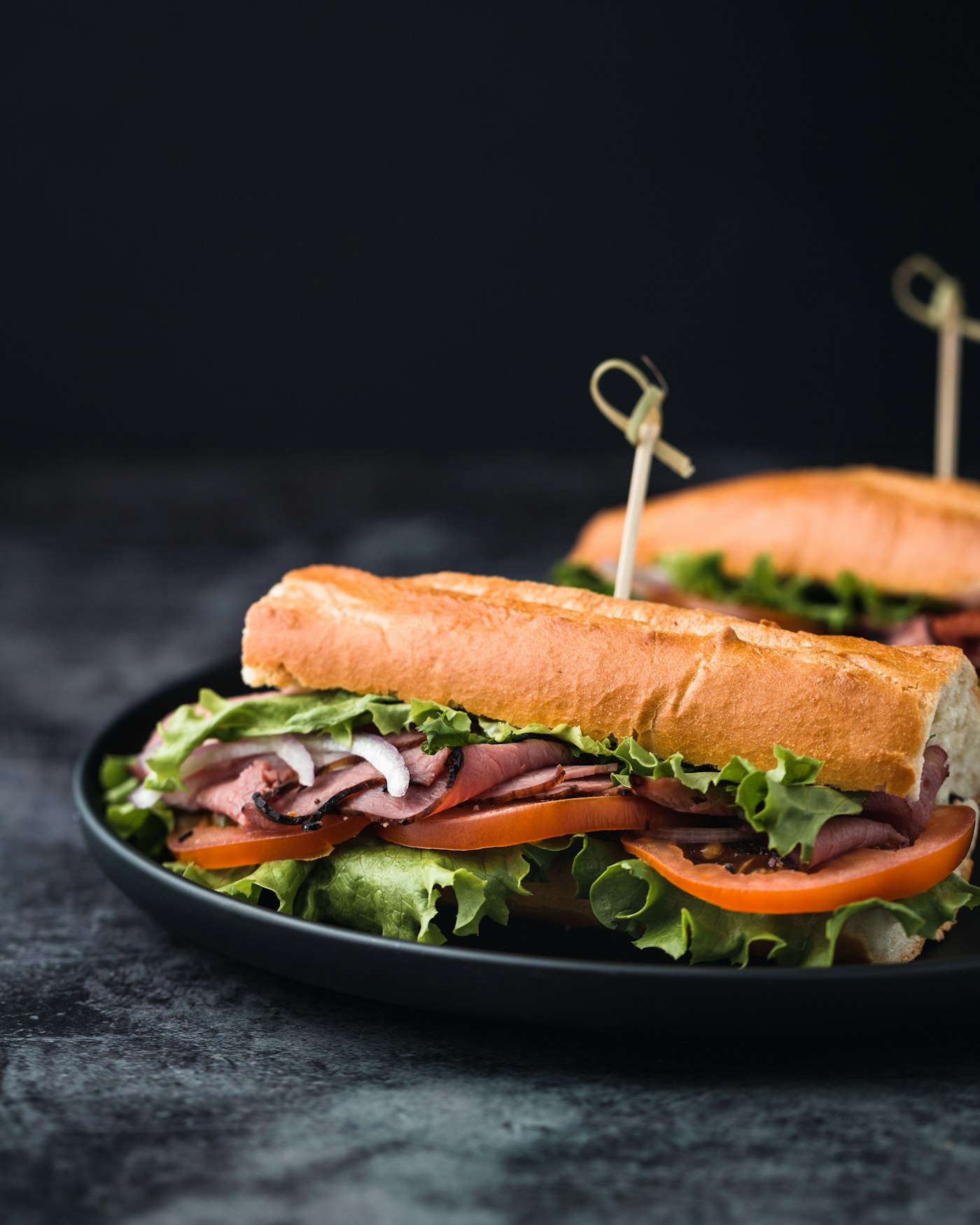 Sandwich baguette garni sur fond sombre